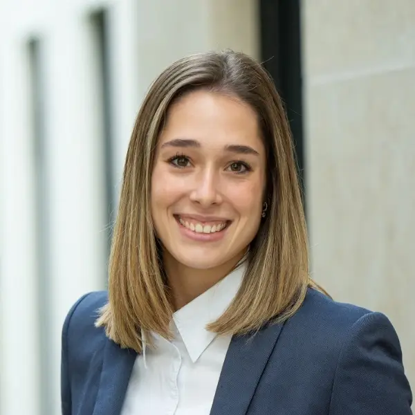 Steuerberaterin Laura Hemm in blauem Blazer und weißer Bluse vor heller Hauswand.
