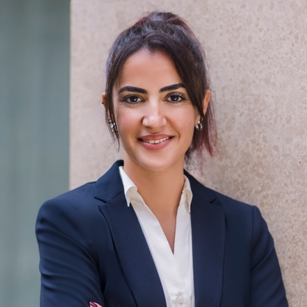 Steuerberaterin Meryem Sultanoglu in blauem Blazer und weißer Bluse vor heller Hauswand