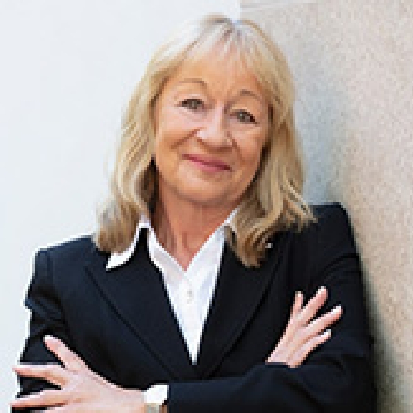 Renate Peischl in blauem Blazer und weißer Bluse vor Hauswand